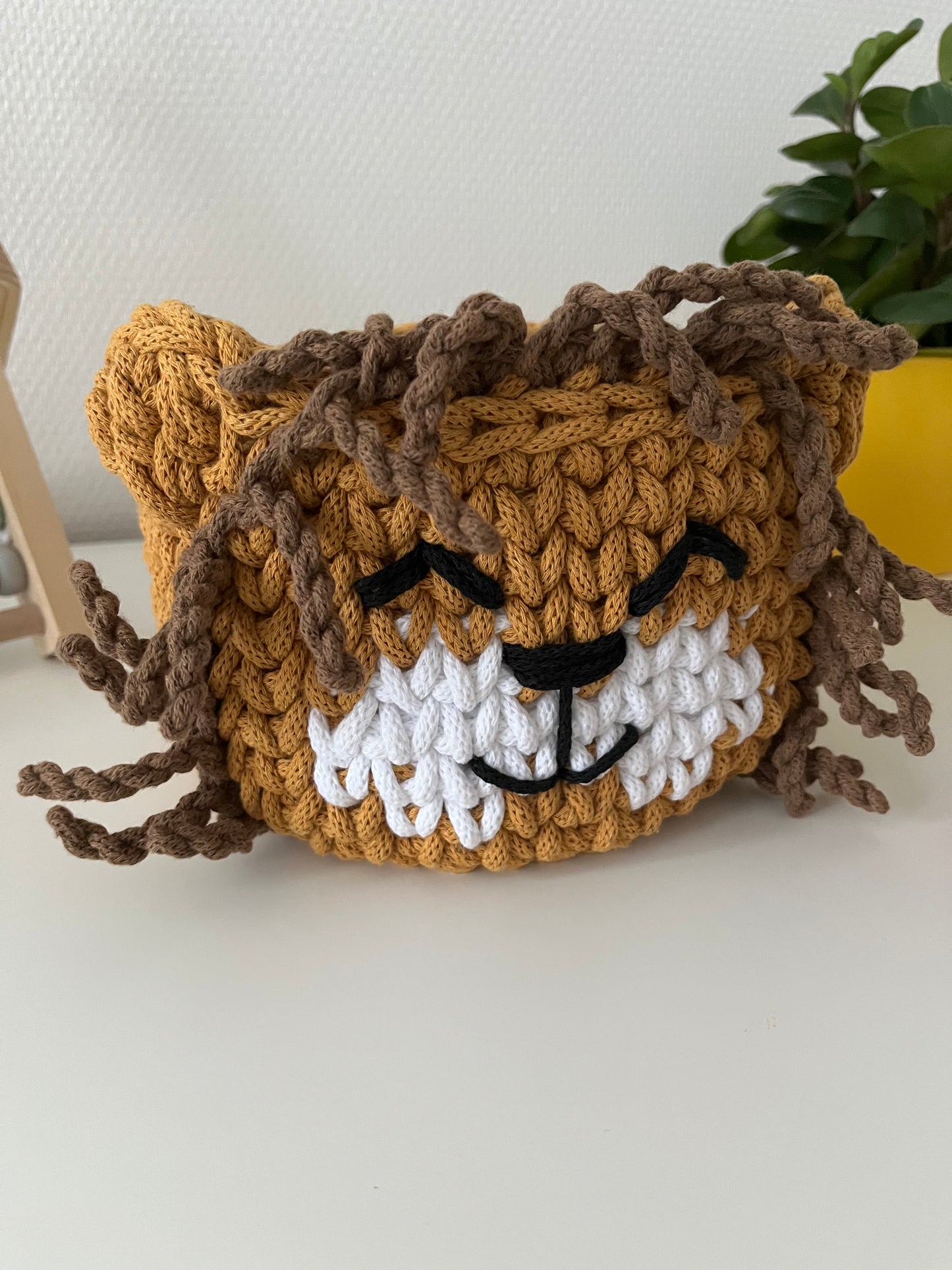 Handmade lion basket made from recycled cotton cord for toy storage in kids room.