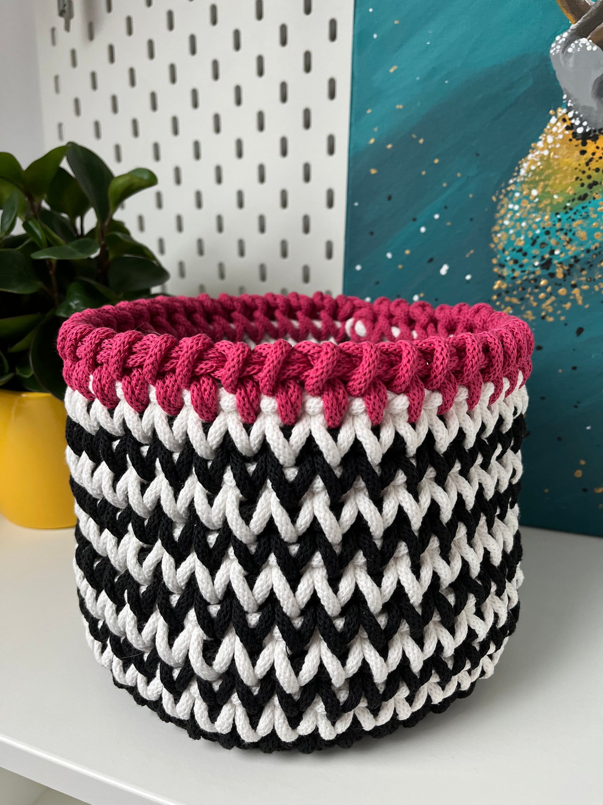 Handmade black and white storage basket with a soft pink trim, crafted from recycled cotton cord. A stylish solution for organising everyday items throughout your home.