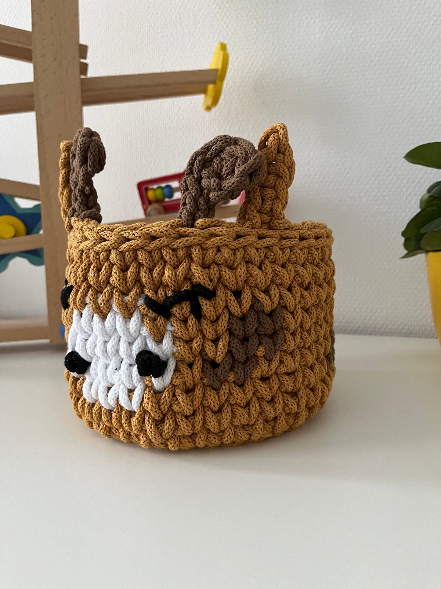 Handmade giraffe basket made from recycled cotton cord for toy storage in kids room. 