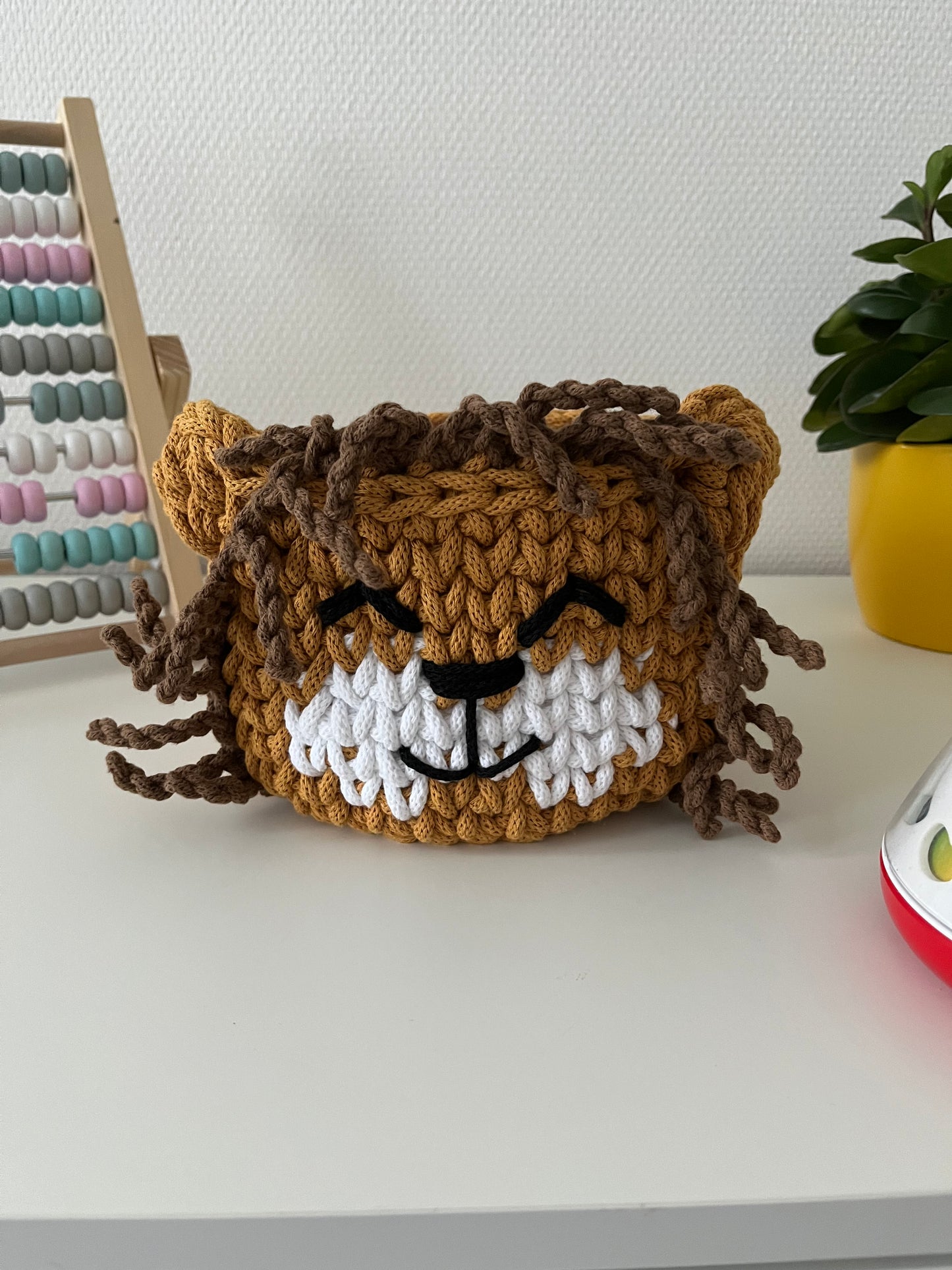 Handmade lion basket made from recycled cotton cord for toy storage in kids room. 