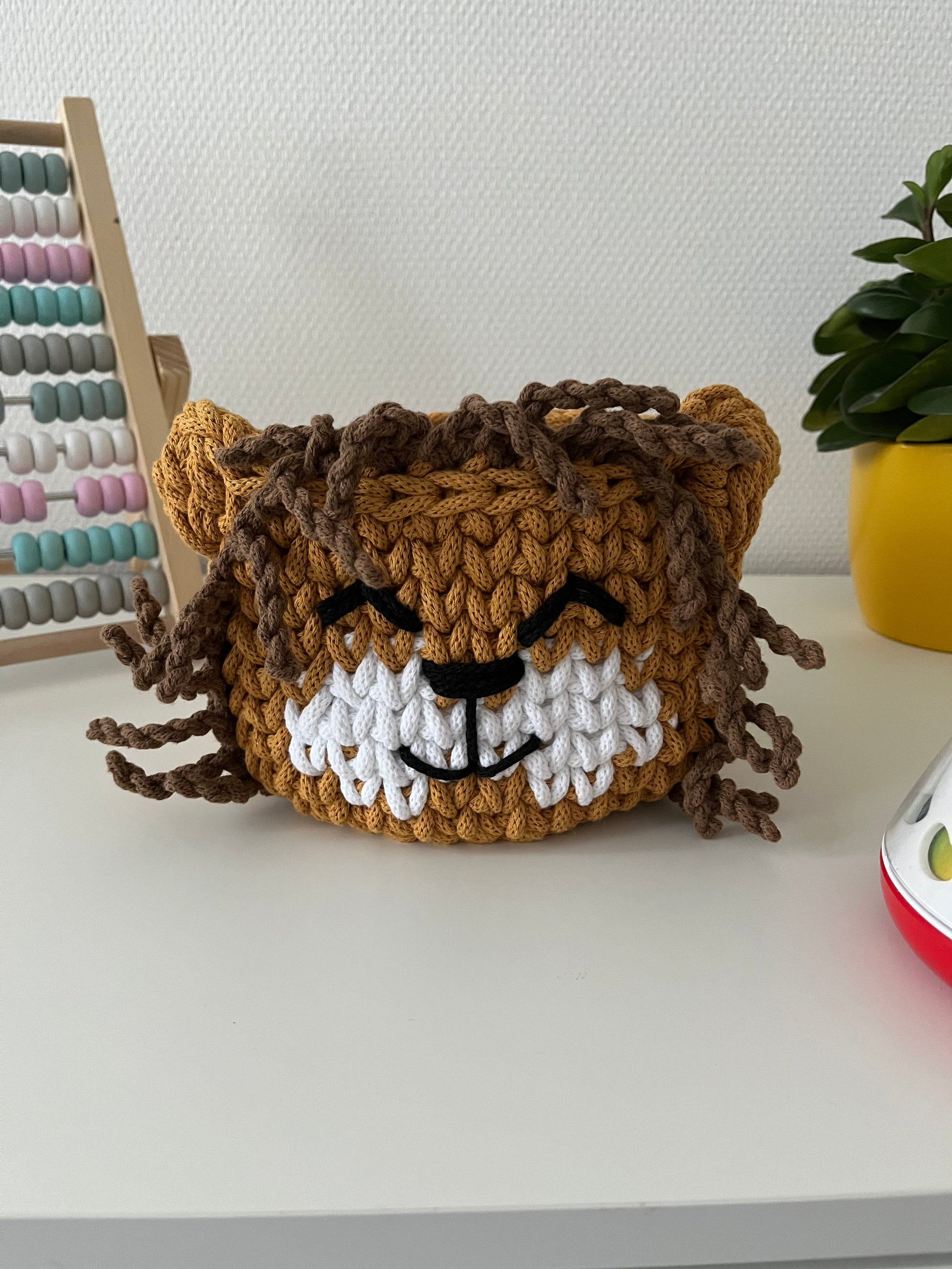 Handmade lion basket made from recycled cotton cord for toy storage in kids room. 