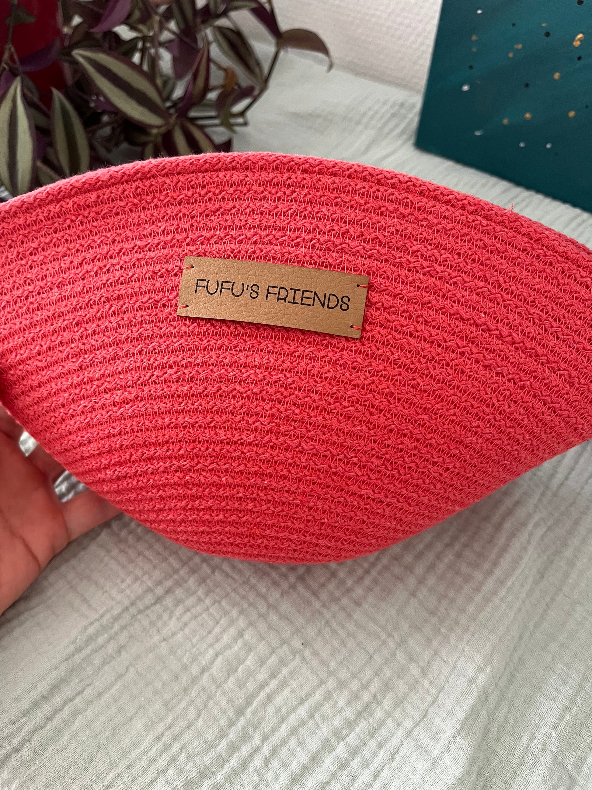 Handmade shell-shaped crochet pouch in coral with zipper closure.