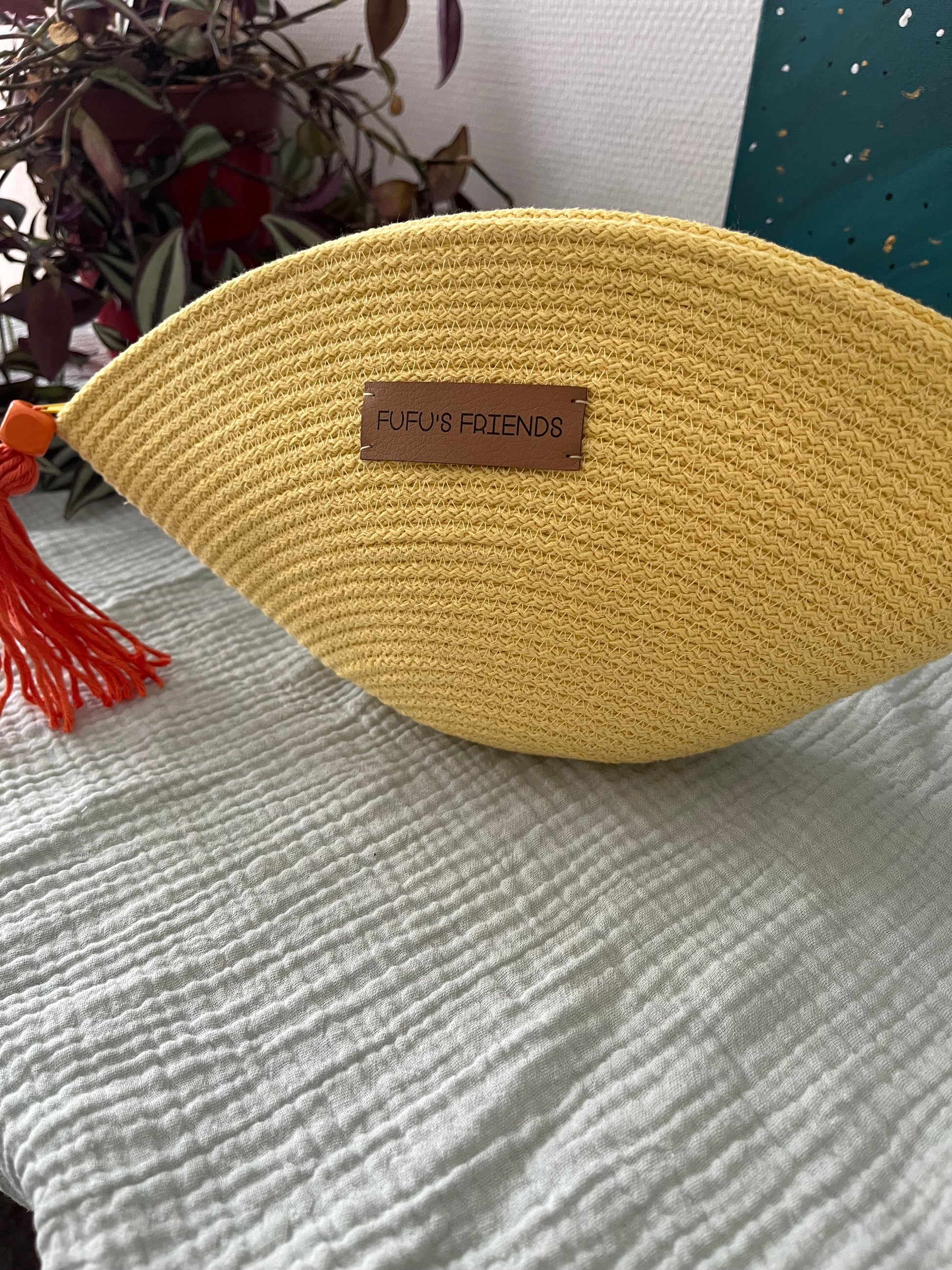 Handmade shell-shaped crochet pouch in yellow with zipper closure.